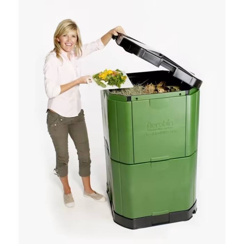 Woman putting kitchen scraps in Brunswick green aerobin hot composter 400 litres