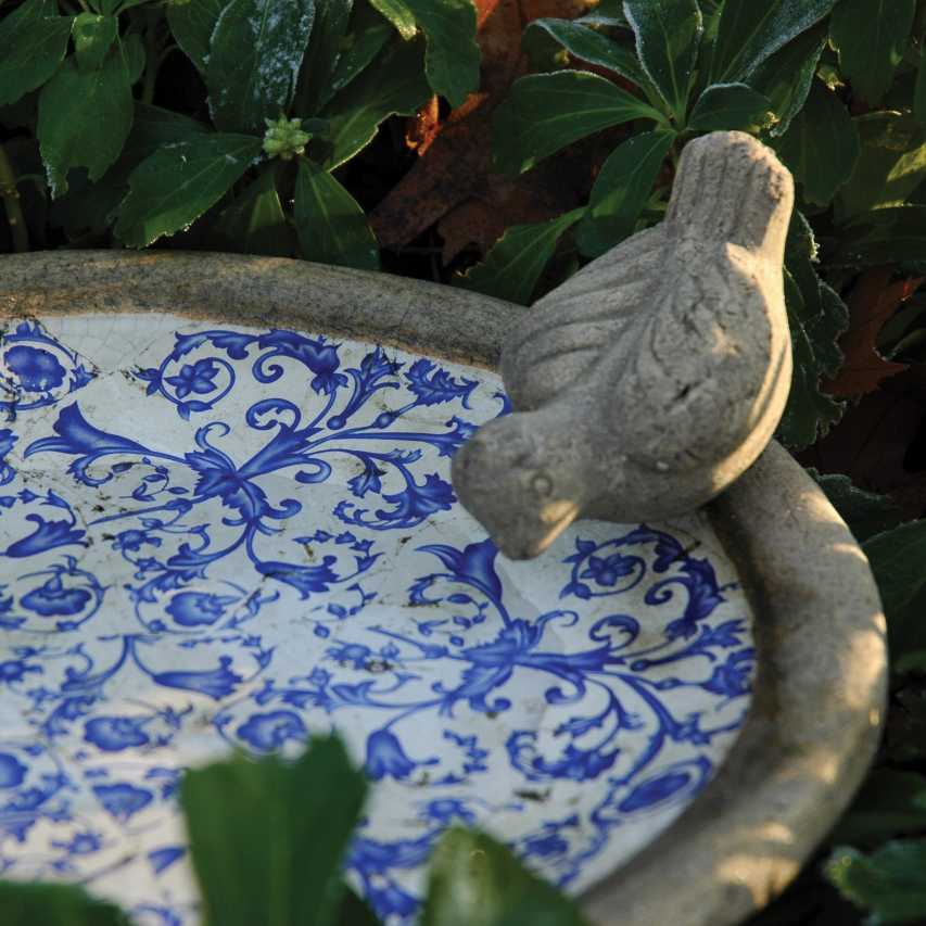 Aged ceramic bird bath bird detail