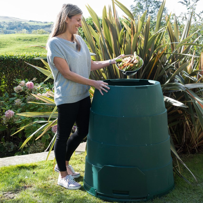 Woman filling Green Johanna 330 litre hot composter with kitchen waste