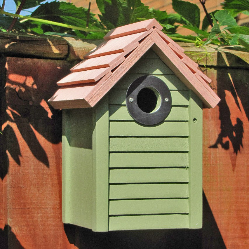 Closeup of New England nestbox in sage green attached to fence in bright sunlight